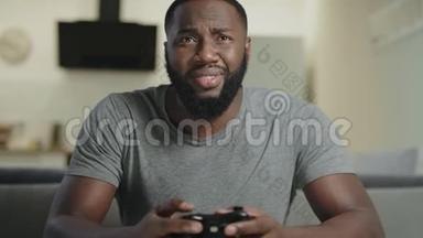 黑人在家玩电子游戏。 一幅黑人男子手持游戏台的肖像